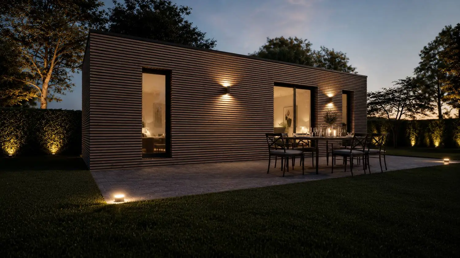 Box aménagé en bardage bois avec terrasse et repas au crépuscule